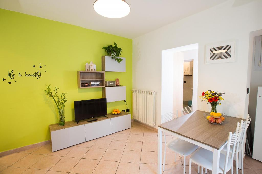 ein Esszimmer mit einem Tisch und einem TV in der Unterkunft Sant’Orsola Apartment in Bologna