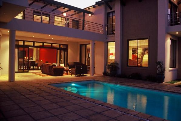 a house with a swimming pool in front of a house at Atlantic Waves Guest House in Cape Town