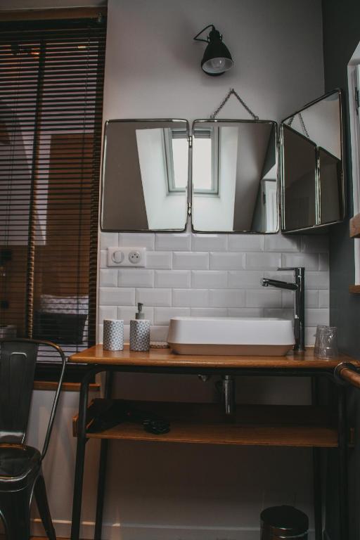 a bathroom counter with a sink and two mirrors at Chambres d&#39;hôtes Saint Jean in Nogent-le-Rotrou