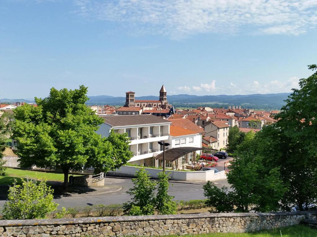 a view of a town with a building and trees at Hôtel Poste et Champanne in Brioude