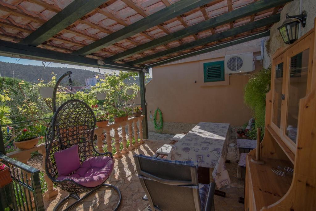 a patio with chairs and a table on a balcony at Cvita A2+1 in Veli Lošinj