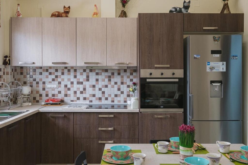 a kitchen with wooden cabinets and a stainless steel refrigerator at Spacious Home with Parking in Chania