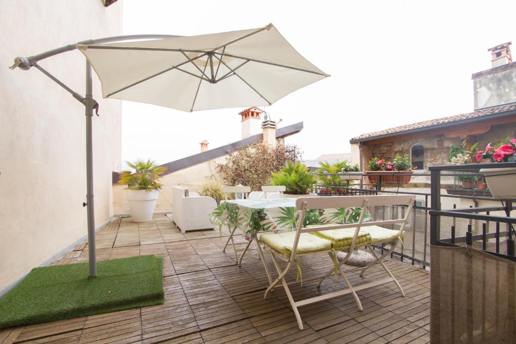 une terrasse avec un parasol, une table et des chaises dans l'établissement Casa Vacanza Fontana Del Delfino, à Bergame