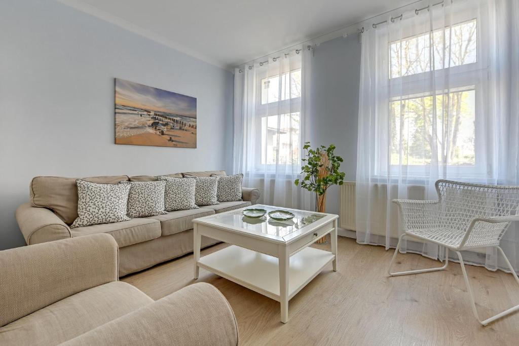 een woonkamer met een bank en een tafel bij Lion Apartments - Parkowa 33Am2 z parkingiem 2 min od plaży in Sopot