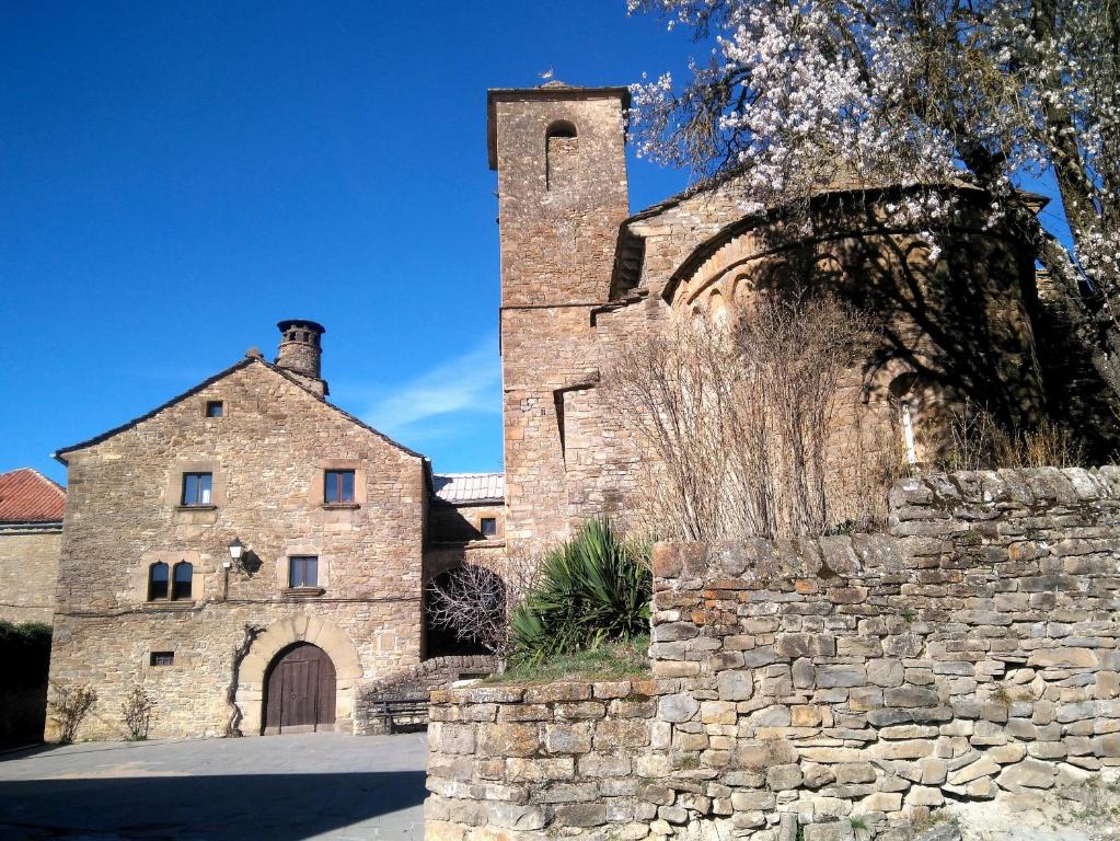 un antiguo edificio de piedra con una torre en la parte superior en CASA-ABADÍA DE BANAGUÁS, en Banaguás