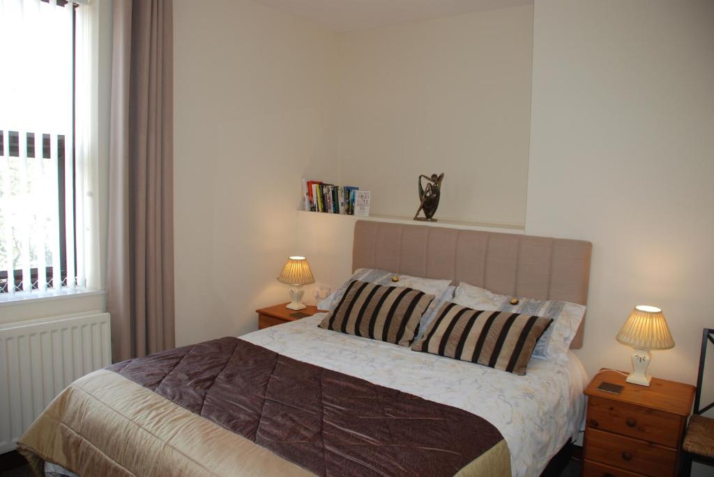 um quarto com uma cama com 2 candeeiros e uma janela em Apartment Bijou em Durham