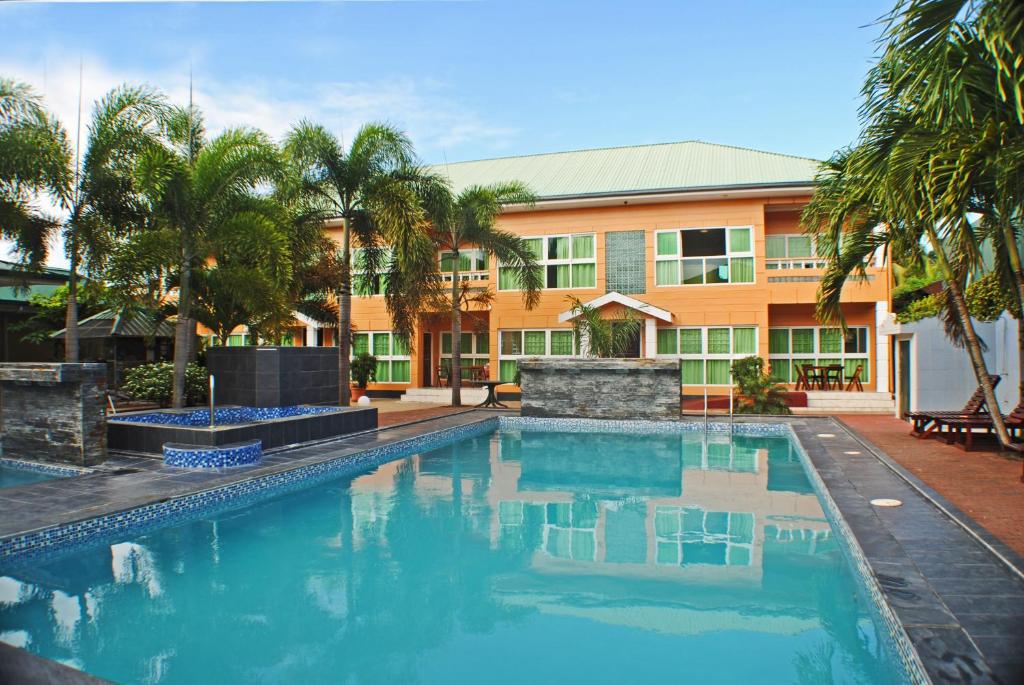 a hotel with a swimming pool in front of a building at Joah Inn Appartementen in Paramaribo