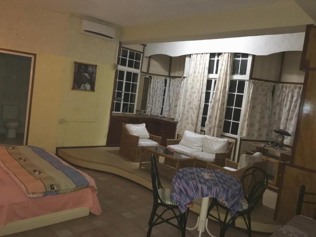 グランベにあるGrand Bay Beach Tourist Residence Mauritiusのベッドルーム1室(ベッド1台、テーブル、椅子付)