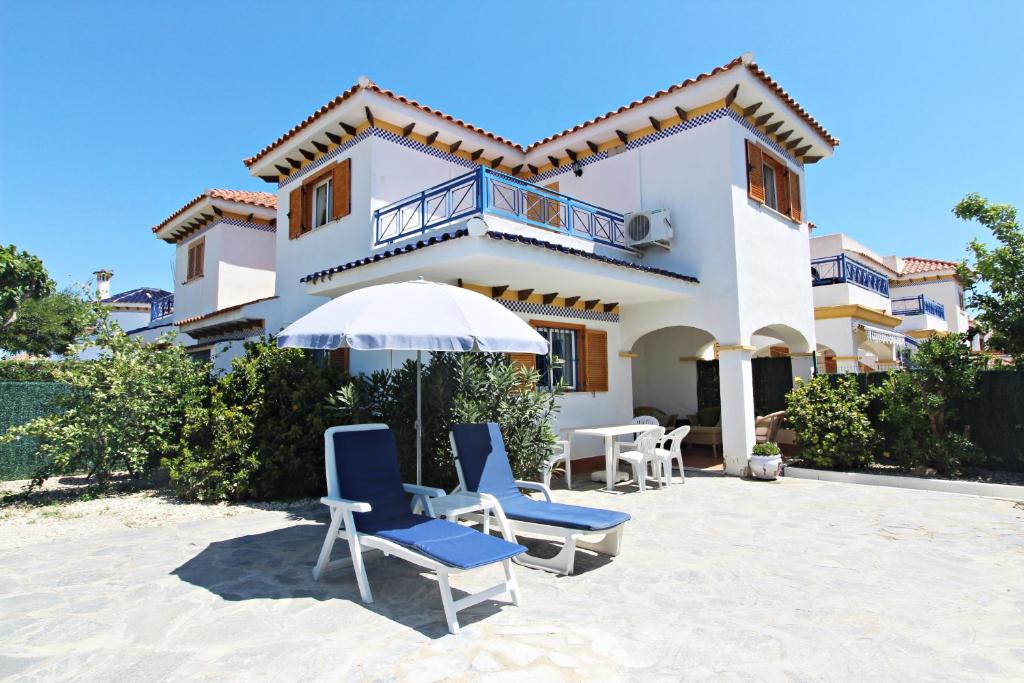 a house with chairs and an umbrella in front of it at Veramar 6 in Vera