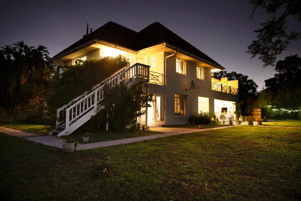 une grande maison blanche avec un escalier dans une cour dans l'établissement 302 On Old Sea View Road Chelsea, à Port Elizabeth