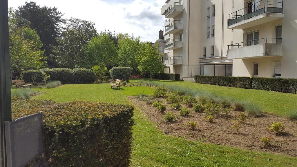 un jardin avec un chien assis dans l'herbe dans l'établissement 31 Bd De Launay, à Nantes