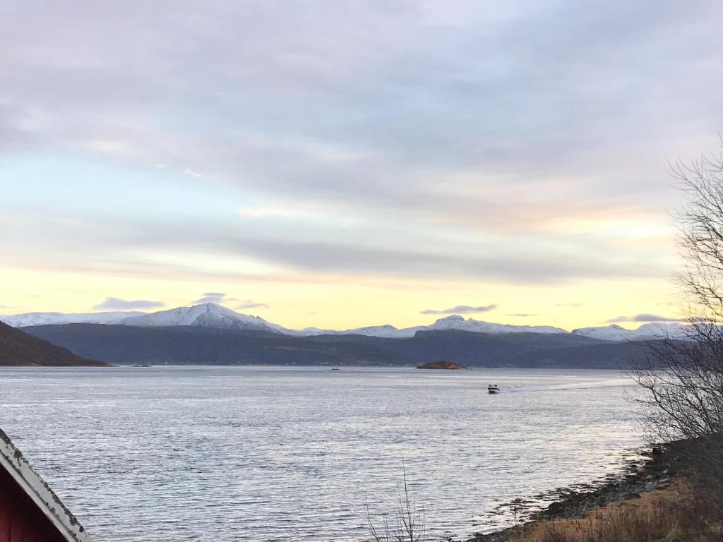 uitzicht op een meer met bergen op de achtergrond bij Kvaløya Lodge in Lanes