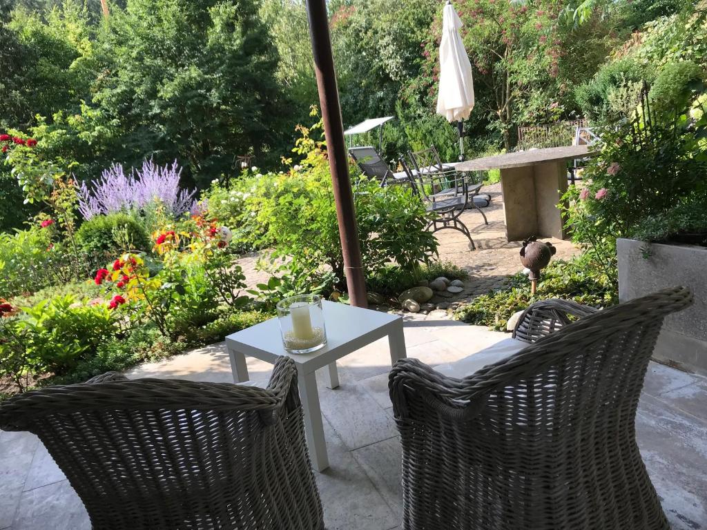 eine Terrasse mit einem Tisch, Stühlen und Blumen in der Unterkunft Ferienwohnung am Weinberg in Randersacker