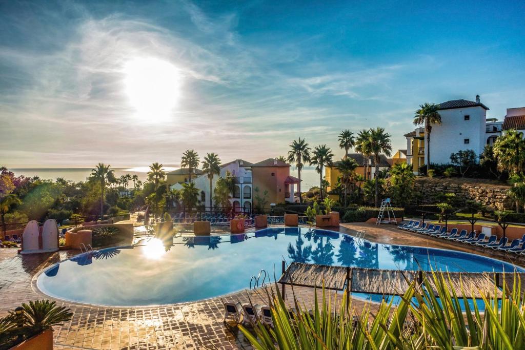 a pool at a resort with a view of the ocean at Aldiana Club Costa del Sol in Alcaidesa