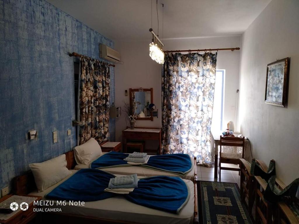 a bedroom with two beds and a window at Adamas Rooms in Palaiochora