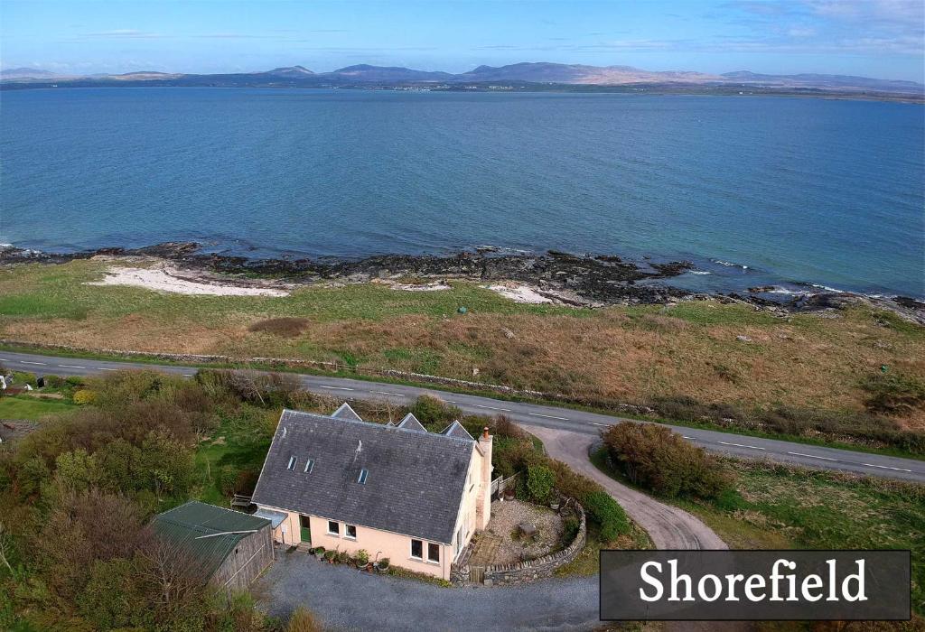 an aerial view of a house next to the water at Shorefield, Bruichladdich in Bruichladdich
