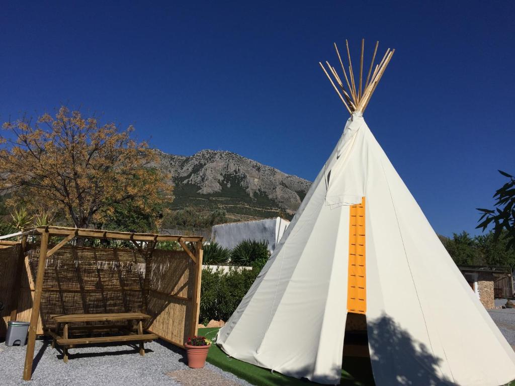 un tipi con una montaña en el fondo en Casa Bella Teepees, en Zújar