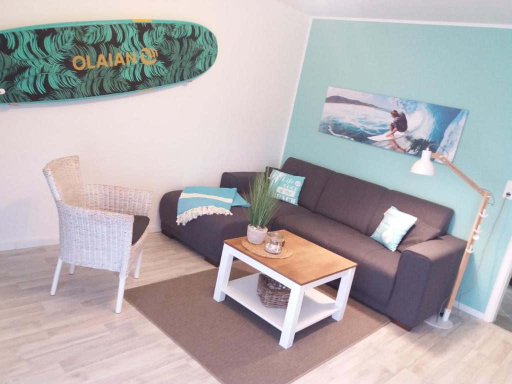 a living room with a couch and a table at Wellenreiter - das appartement in Schönhagen