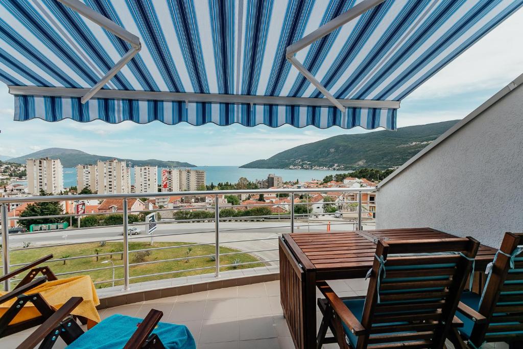 a balcony with a table and chairs and a view at Boka View in Igalo