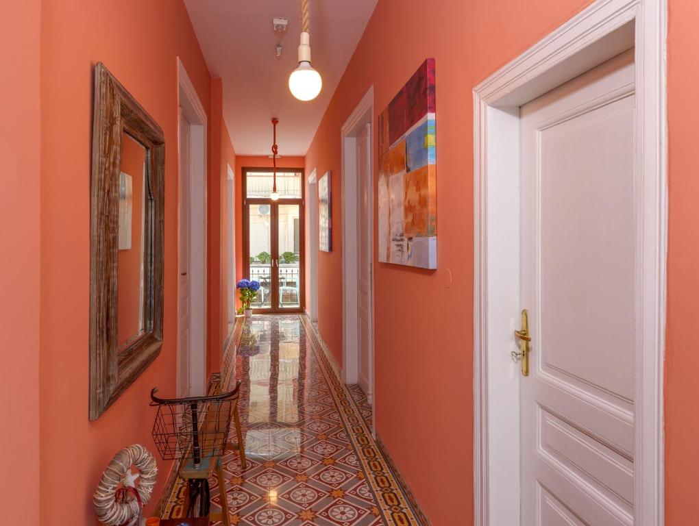 un pasillo con paredes de color naranja y una puerta blanca en TheJoy, en La Canea