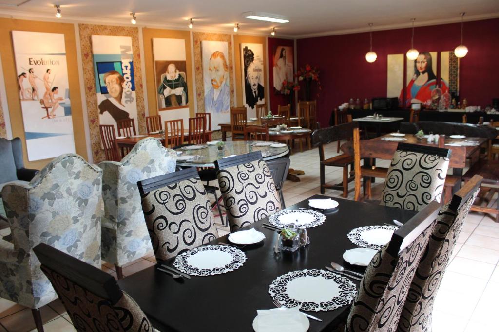 uma sala de jantar com uma mesa com pratos em House and Heart Guest House em Vanderbijlpark