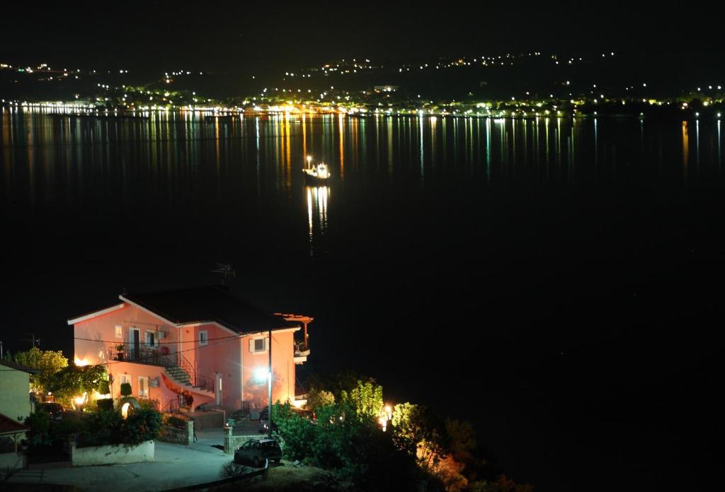 a house on the shore of a lake at night at Alicia studios in Fársa