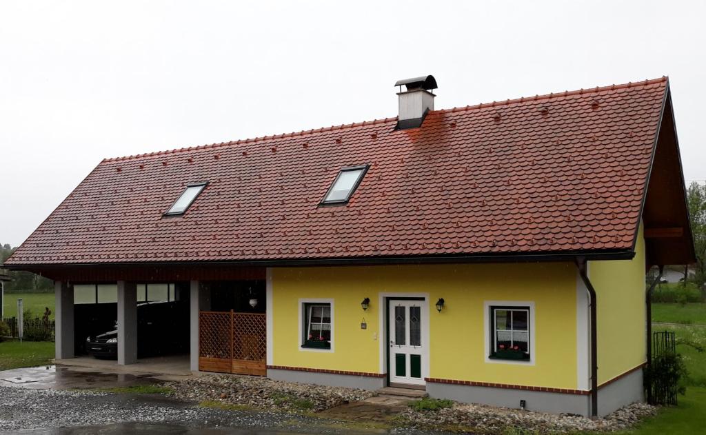 una pequeña casa amarilla con techo marrón en Russhof-Fam.Thomann, en Stainz
