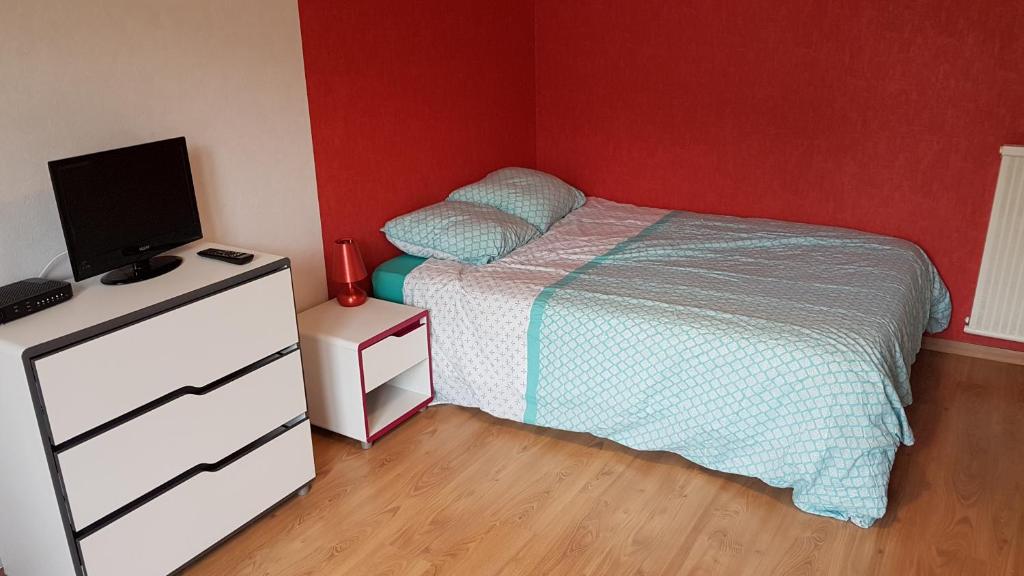 Schlafzimmer mit einem Bett und einer Kommode mit einem TV in der Unterkunft Studio Beaulieu in Rennes