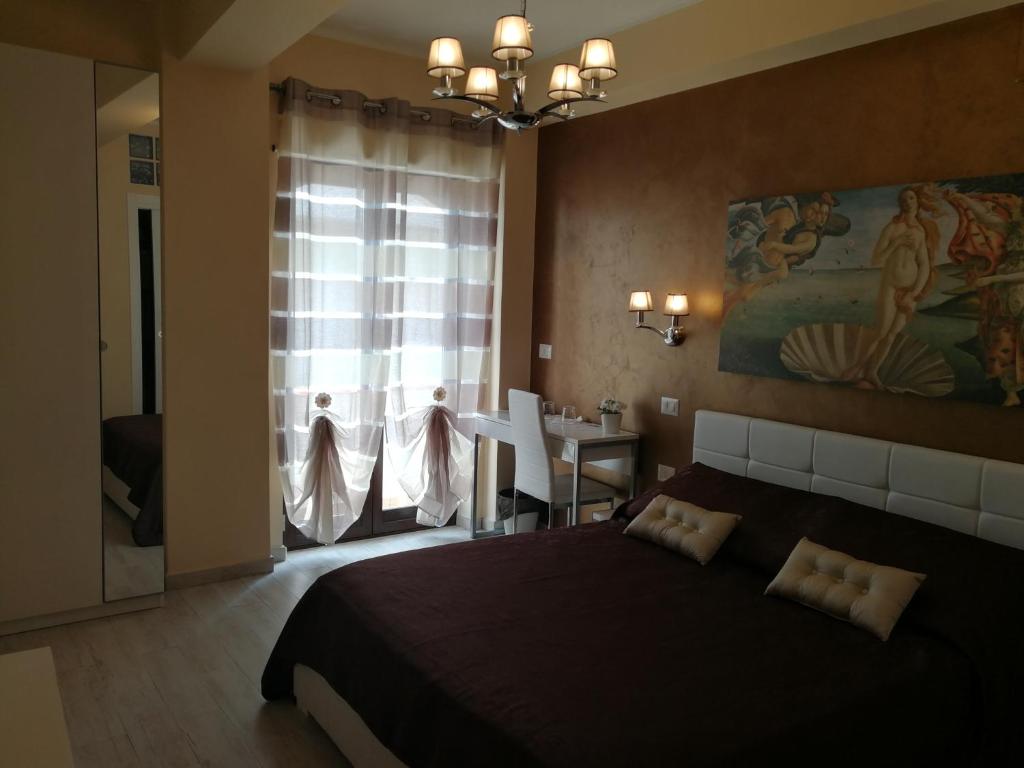 a bedroom with a large bed and a dining room at B&B Il Mare degli Dei in Letojanni