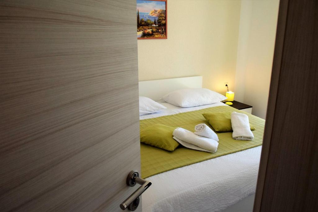 ein Schlafzimmer mit einem Bett mit zwei Handtüchern darauf in der Unterkunft Apartments Kampor in Rab
