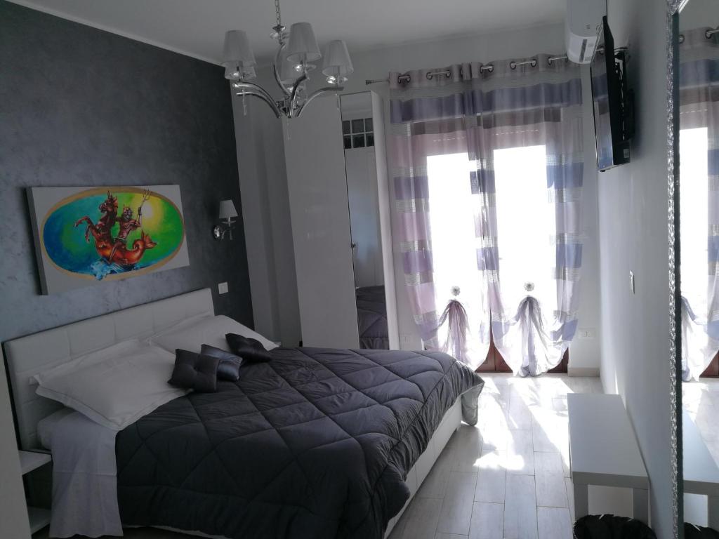 a bedroom with a bed and a large window at B&B Il Mare degli Dei in Letojanni