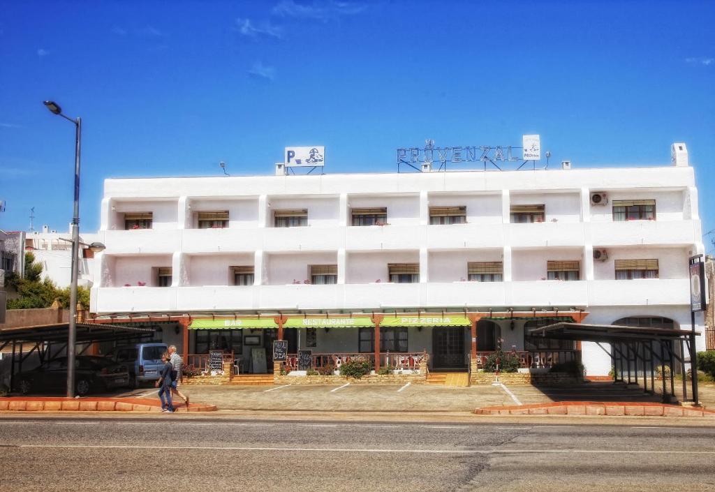 un edificio blanco con un hombre caminando delante de él en Pensión Provenzal, en Mojácar