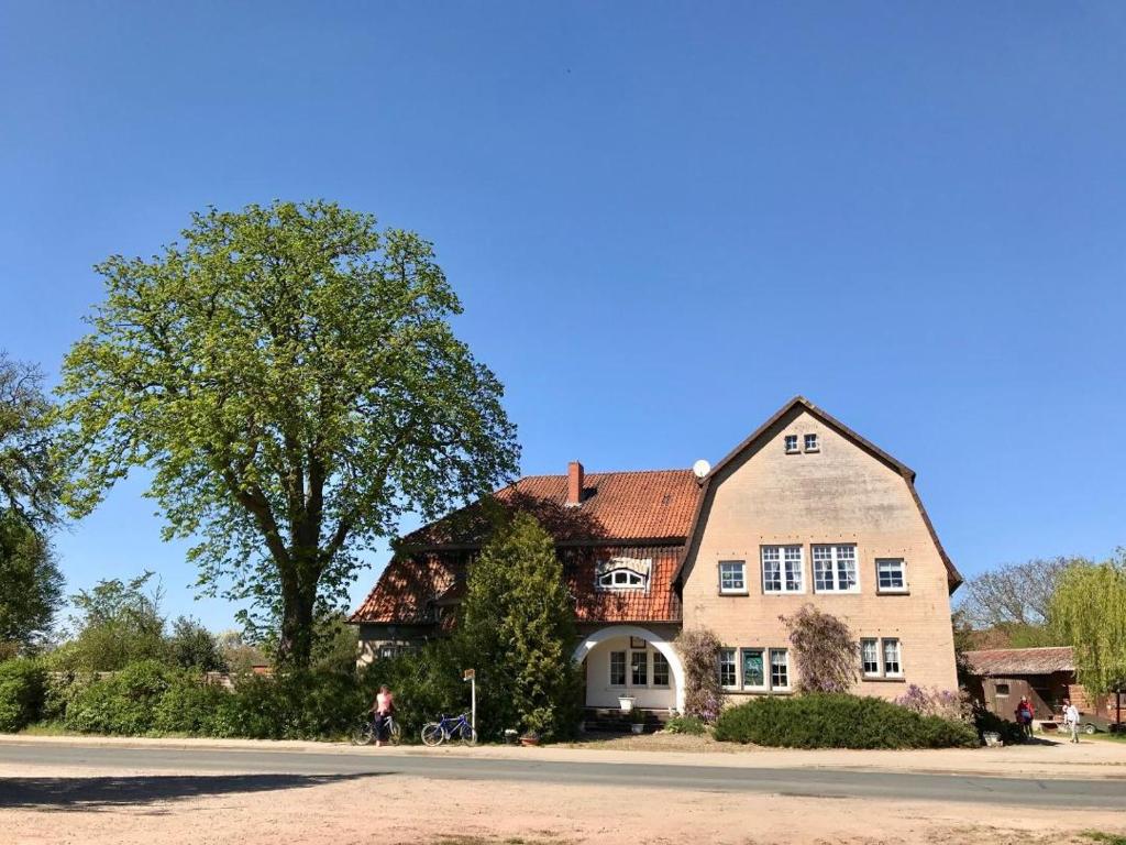 a large house with a tree in front of it at Zum Bothmerschen Krug in Schwarmstedt