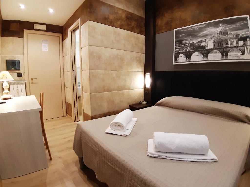 Un dormitorio con una cama con dos toallas encima. en Gialli Vatican Guesthouse, en Roma