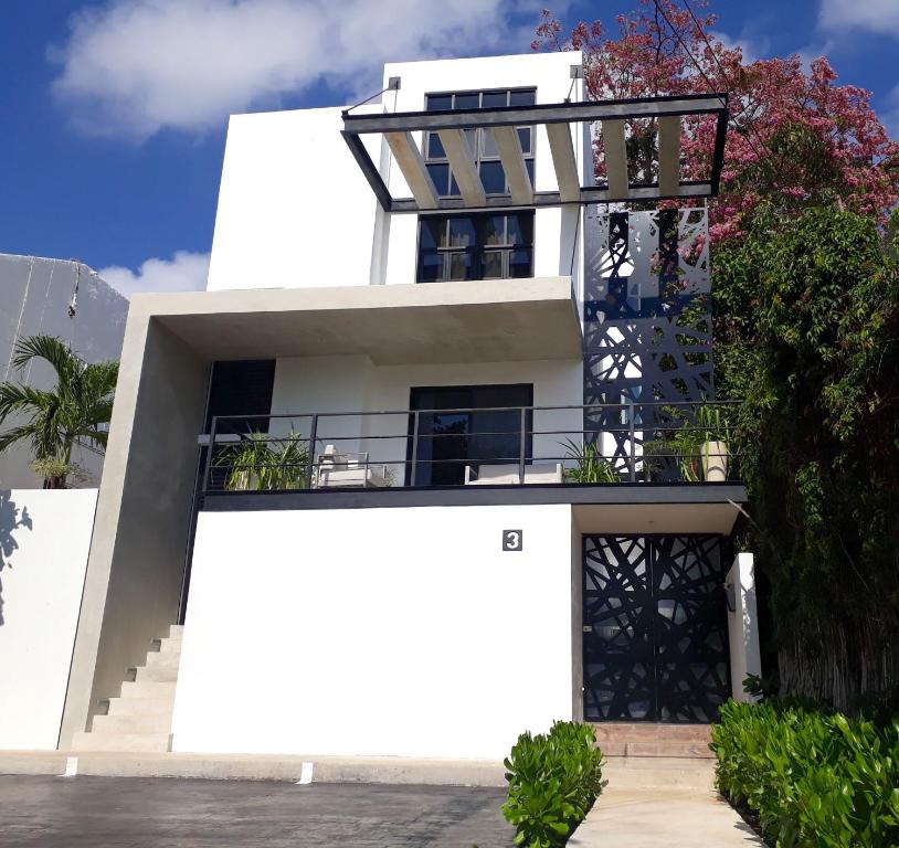 Un edificio blanco con un balcón. en TR3S by Walter de la Renta, en Cancún