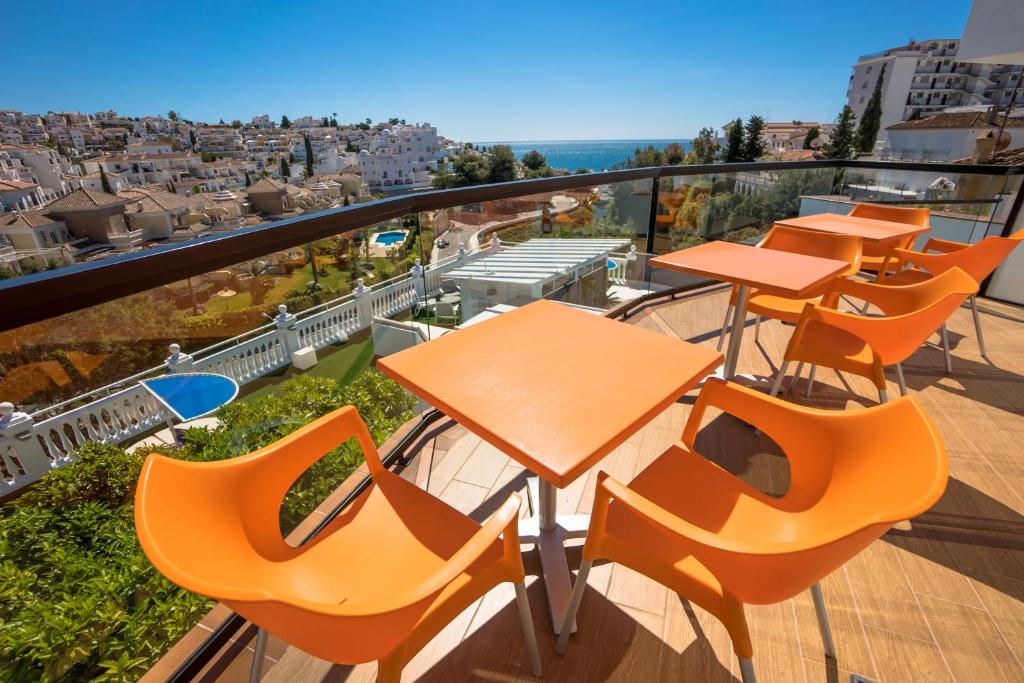 a row of tables and chairs on a balcony at Hostal Casa Mercedes in Nerja