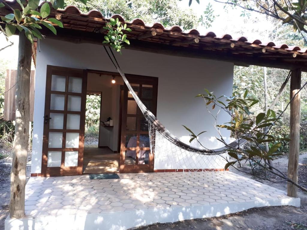 Chalé da Mangueira في فالي دو كاباو: منزل أمامه أرجوحة