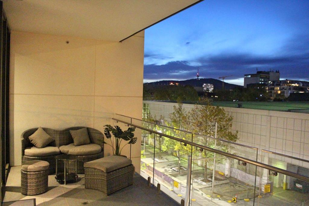 a balcony with a couch and a chair on a building at Perfectly Located Modern Apartment - Canberra CBD in Canberra