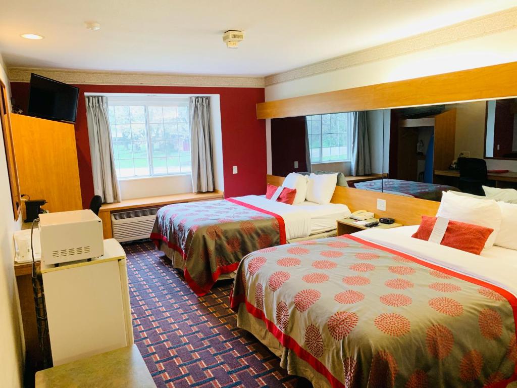 Habitación de hotel con 2 camas y TV en Ramada Limited and Suites Bloomington, en Bloomington