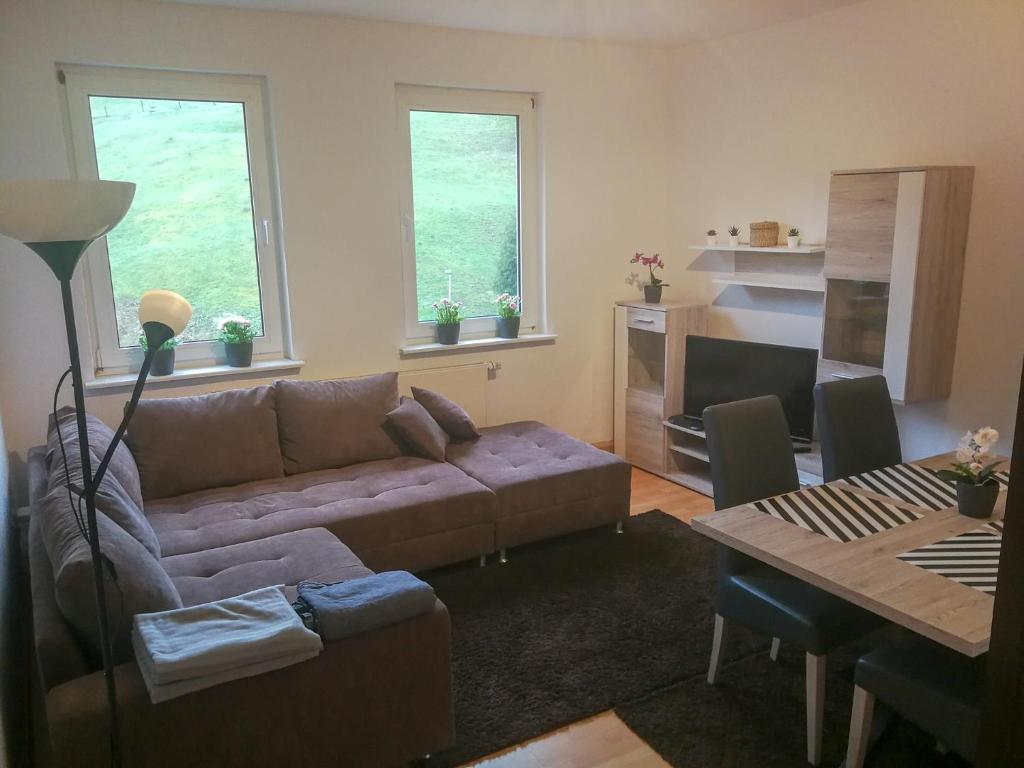 - un salon avec un canapé et une table dans l'établissement FeWo Bergblick, à Osterode