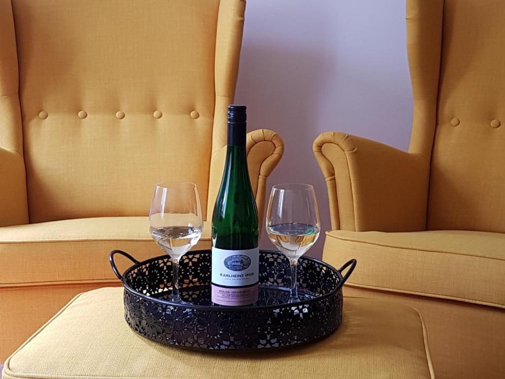 - une bouteille de vin et 2 verres à vin sur une table dans l'établissement Haus Anna, à Zell