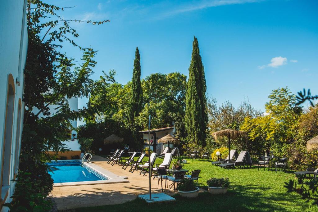 a yard with chairs and a swimming pool at Casa de Cacela in Vila Nova De Cacela