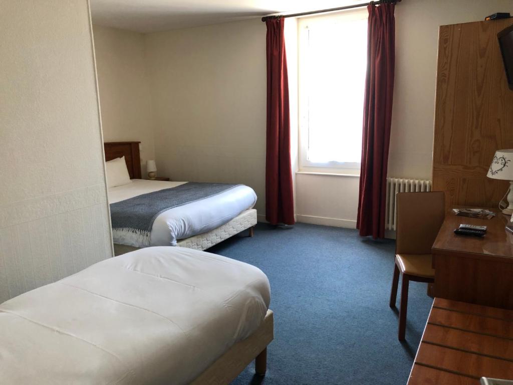 Säng eller sängar i ett rum på Hôtel d'Arromanches Pappagall