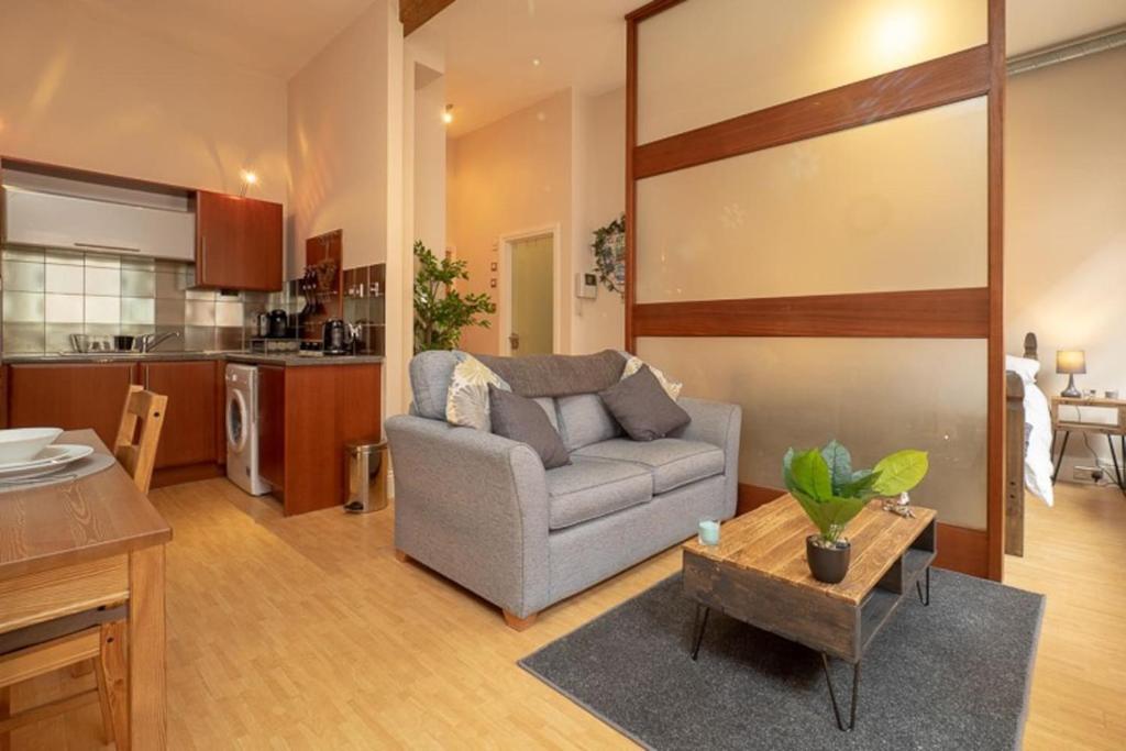 uma sala de estar com um sofá e uma mesa em Stylish and comfortable Lace Market Studio Apartment em Nottingham
