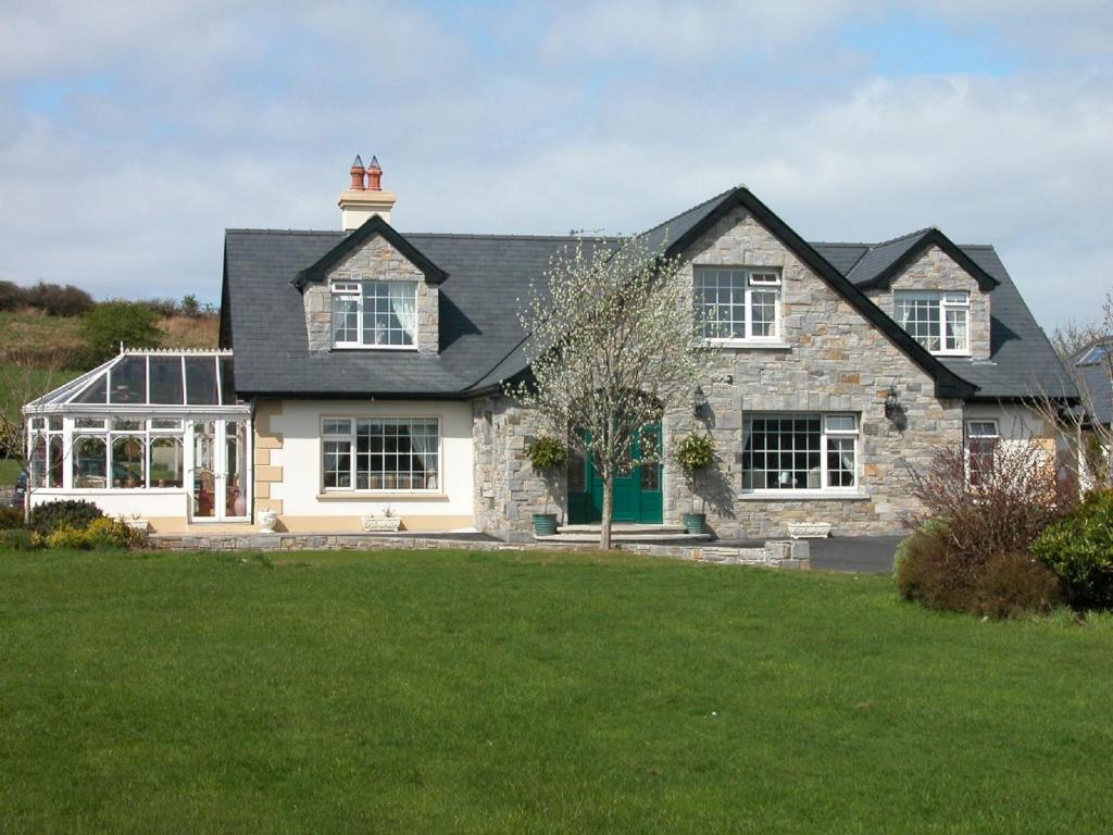 a house with a green lawn in front of it at Glenderan B&B in Westport