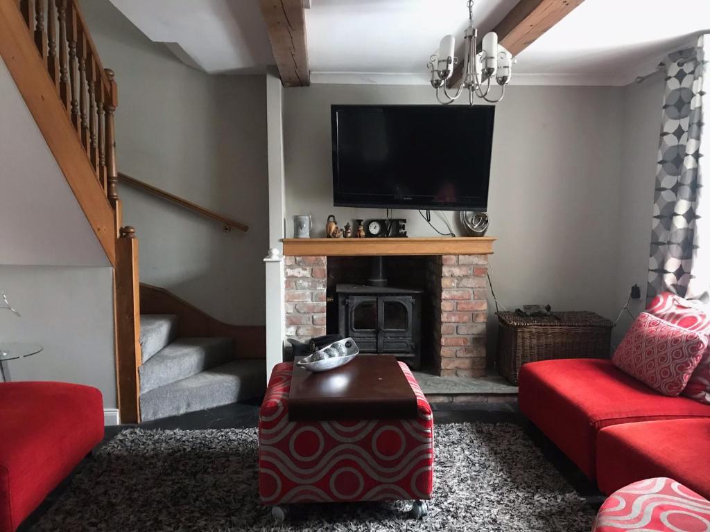 a living room with a fireplace and a flat screen tv at Beautiful Family Home in Greyabbey