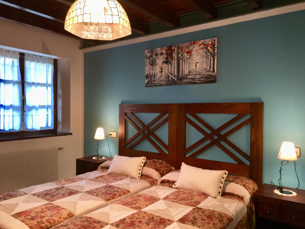 1 dormitorio con 1 cama, 2 mesas y 2 lámparas en Apartamentos Palombina, en Celorio