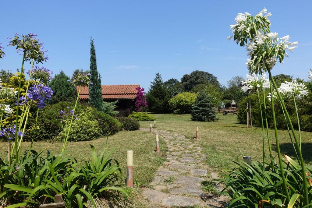 a garden with a stone path and flowers at La Casa del Carballo in Pisones