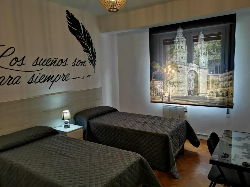 ログローニョにあるApartamentos Avenida de La Pazのベッド2台が備わる部屋、壁に絵が飾られた部屋