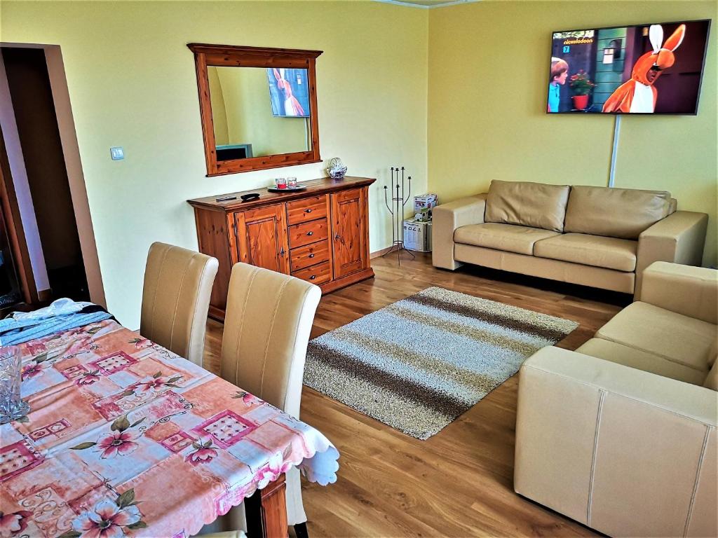 a living room with a table and a couch at Apartament blisko Świeradowa in Mirsk